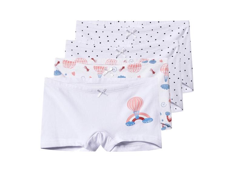 Vier paar witte kinderboxershorts, twee met stippen, twee met heteluchtballonnen.
