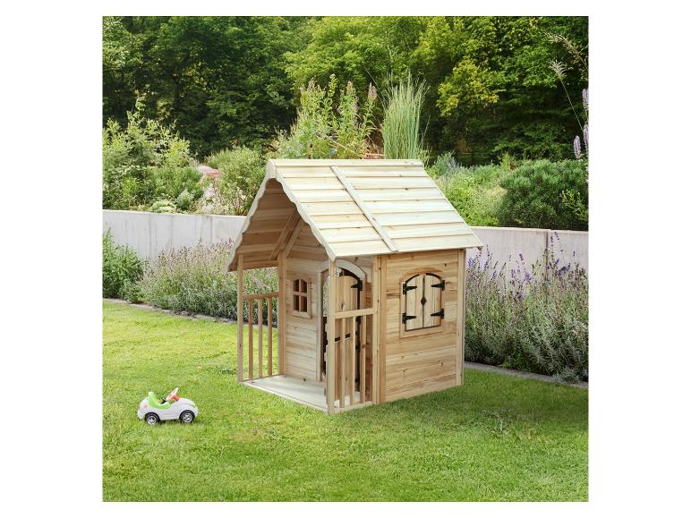Houten speelhuisje met een kleine speelgoedauto in een groene tuin.