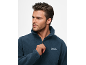 Man in blauwe fleece trui met rits, kijkt opzij.