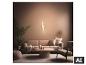 Moderne woonkamer met een beige bank, fauteuil, salontafel en een decoratieve wandlamp.
