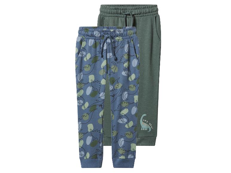 Twee kinderjoggers: één blauw met dinosauruspatroon en één groen met een dinosaurus en de tekst 'hey you!'.