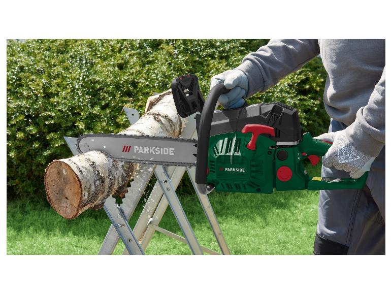 Man zaagt hout met een Parkside kettingzaag op een zaagbok in de tuin.