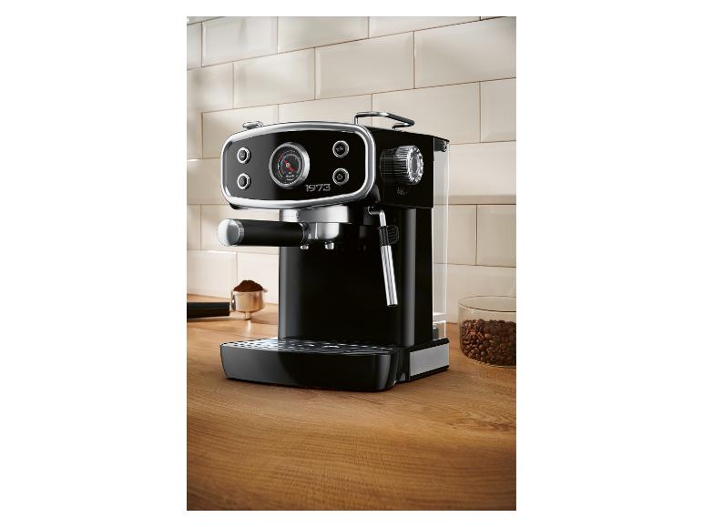 Zwart espressomachine op een houten aanrecht met koffiebonen en gemalen koffie