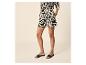 Vrouw in zwart-witte abstracte shorts en shirt met lange mouwen.
