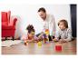 Vader en kinderen spelen op de vloer met educatieve bouwblokken en kaarten.