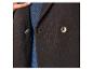 Close-up van een donkerbruine blazer met twee knopen, gedragen over een blauw spijkeroverhemd.