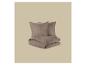 Bruin mousseline beddengoedset met twee kussens en een opgevouwen dekbed.