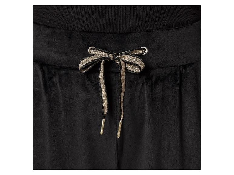 Zwarte fluwelen broek met beige en zwarte veters.