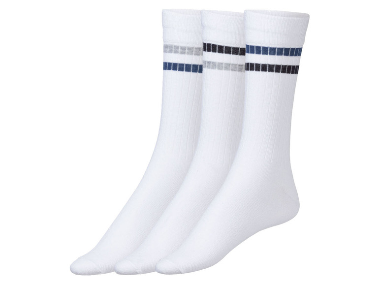 Drie paar witte sokken met gekleurde strepen.