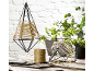 Decoratieve metalen frames met touw, planten en een rol touw op een houten tafel.