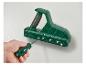Een hand die een schroevendraaier gebruikt om een groen gereedschap met messen vast te zetten.