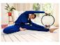 Vrouw in blauwe sportkleding gebruikt een Pilatesring tijdens een rek- en strekoefening.