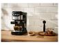 Zwart-zilveren espressomachine zet twee kopjes koffie in een moderne keuken.