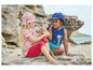 Twee kinderen in zomerkleding op het strand met schelpen.