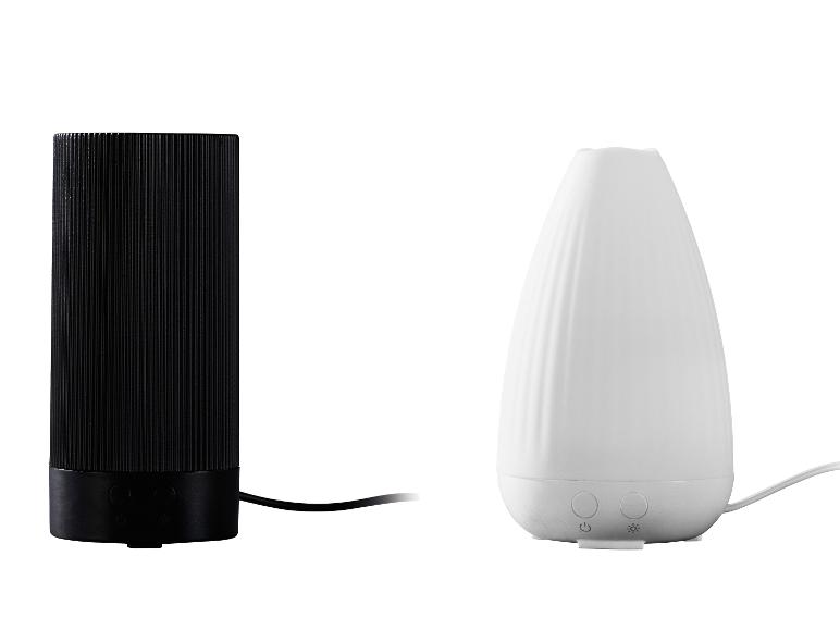 Twee aroma diffusers: een zwarte cilindervormige en een witte druppelvormige.