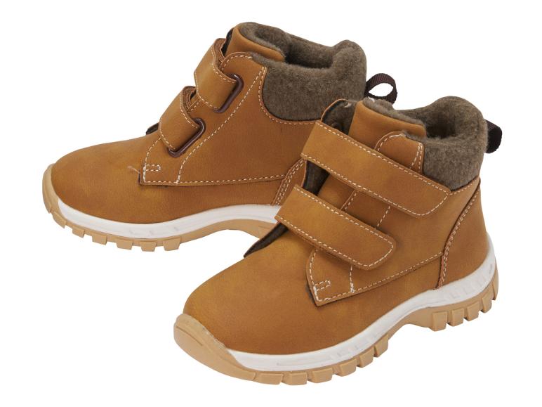 Paar bruine kinderlaarzen met klittenbandsluiting en witte zool.
