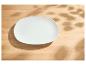 Leeg wit bord op een houten tafel met bladschaduwen