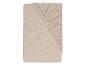 Gevouwen lichtbeige mousseline hoeslaken.