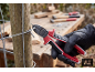 Persoon met handschoenen knipt draad met tang bij een houten paal.