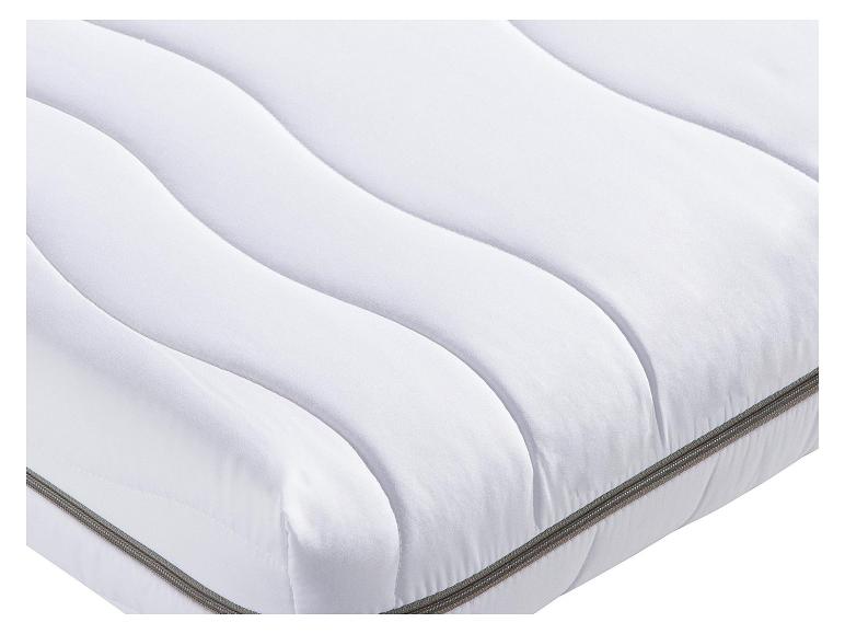 Witte matras met gebogen stiksels en grijze rits.