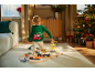 Kind in kersttrui speelt met houten treinbaan en bouwspeelgoed.