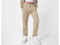 Beige joggingbroek en bijpassende hoodie, met witte sneakers.