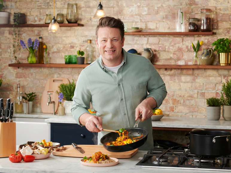 Een man kookt een curry gerecht in een pan.