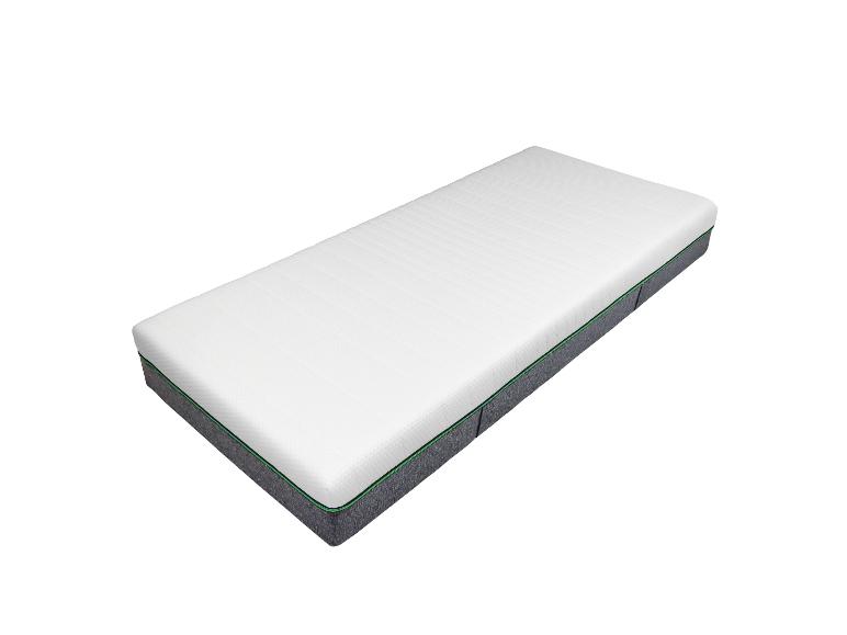 Een wit matras met grijze en groene details.
