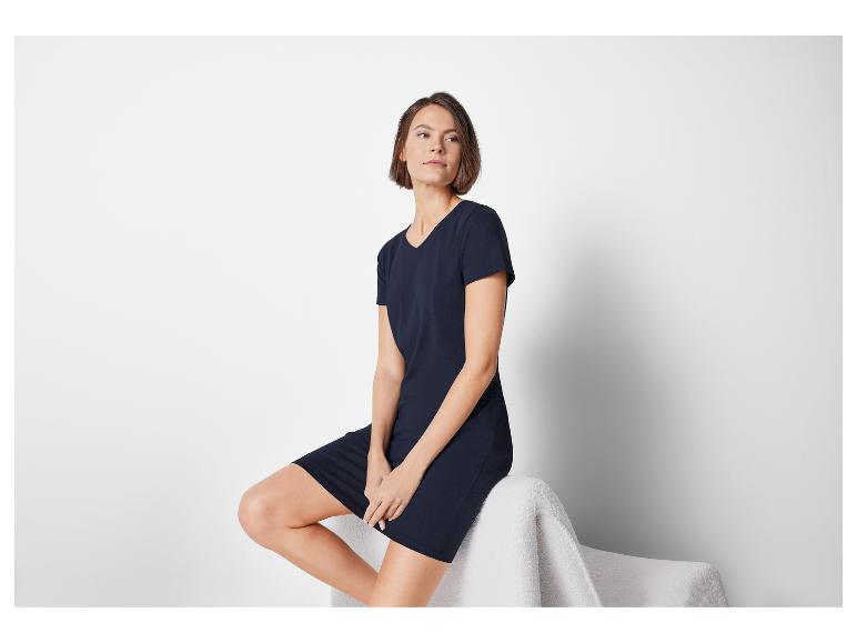 Model in een donkerblauwe t-shirtjurk.
