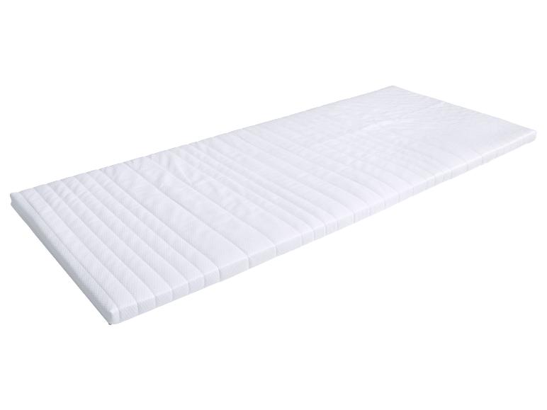 Wit gewatteerd matras met gestreept patroon, vanuit een hoek gezien.