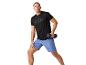 Man die oefeningen doet met dumbbells, draagt een sport shirt en short.