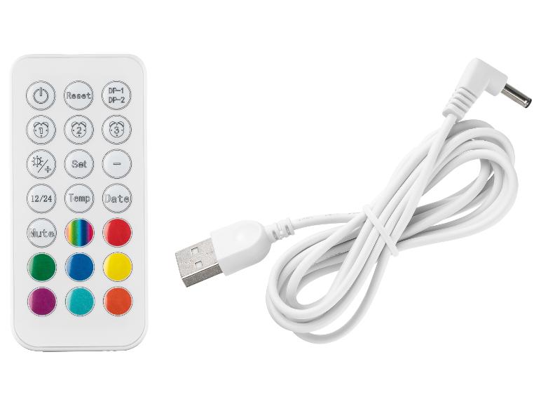 Witte afstandsbediening met kleurrijke knoppen en een USB-oplaadkabel.