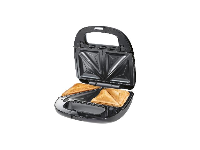 Een zwarte tosti-ijzer met twee gebakken tosti's