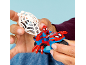 Handen houden een rode en blauwe speelgoedmotor met een superheldenfiguur en een wit web.