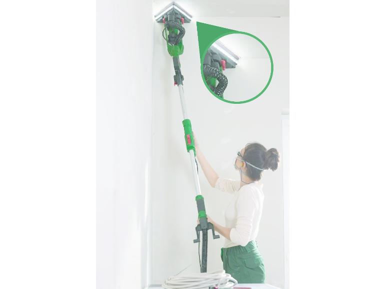 Vrouw schuurt muurhoek met telescopische schuurmachine met LED-verlichting.
