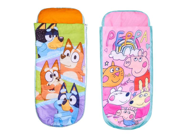 Twee kinderslaapzakken, één met tekenfilmhonden en de andere met tekenfilmvarkens.