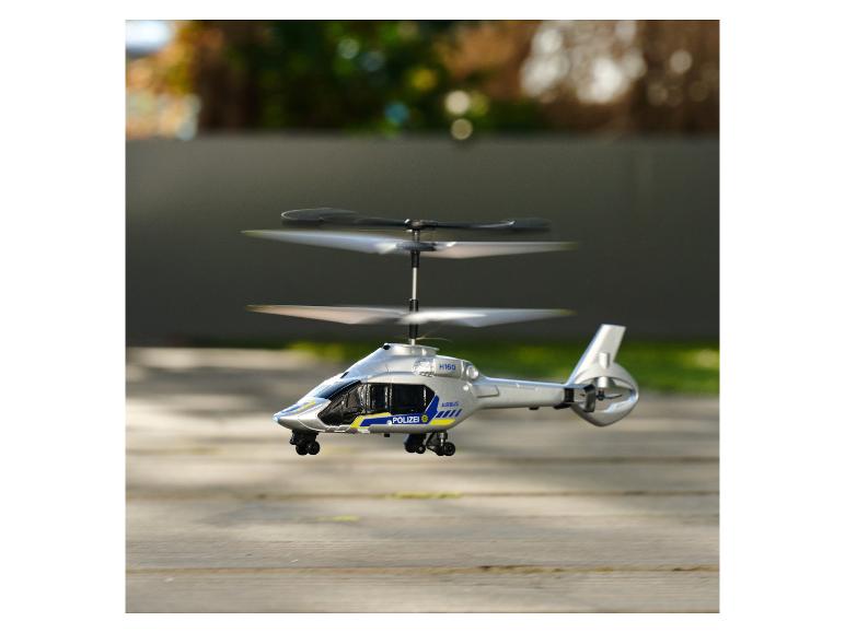Zilveren Airbus H160 politiehelikoptermodel zweeft in de lucht.