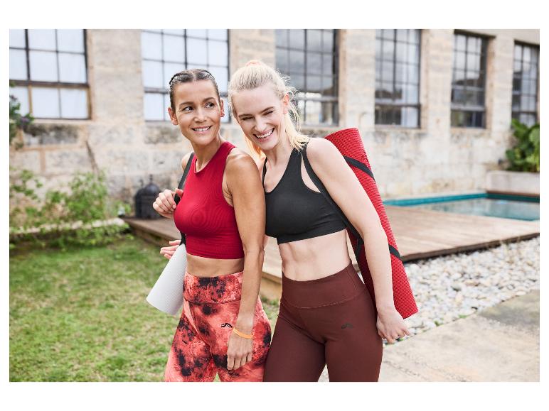 Twee vrouwen in Gymshark sportkleding dragen yogamatten.
