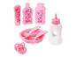 Een roze babyfles, een bord met bestek, een speen en twee flessen met een vogeltje-ontwerp.
