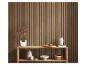 Houten lattenwand met een houten plank met diverse decoratieve items.