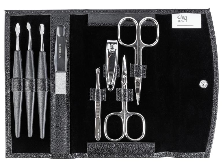 Een zwarte leren etui met nagelverzorgingsproducten, waaronder twee scharen, een nagelknipper en een vijl.