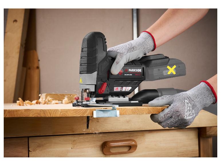 Een persoon gebruikt een decoupeerzaag om een houten plank te zagen.