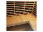 Licht houten sauna-interieur met L-vormige bank en lattenrugleuning.