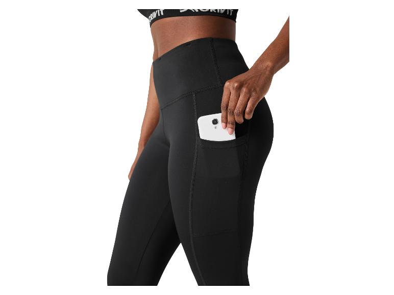 Zwarte sportlegging met zijzak en een smartphone erin, gedragen door een vrouw.