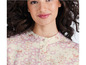 Een vrouw draagt een lichtgekleurde blouse met een bloemenprint.