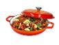 Oranje braadpan met deksel, gevuld met gesneden groenten zoals courgette, paprika en ui.