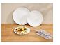 Wafels met fruit, twee witte borden en bestek op een houten tafel.