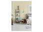 Slaapkamer met bed, fauteuil, rek, houtstapel en mintgroene hanglamp.