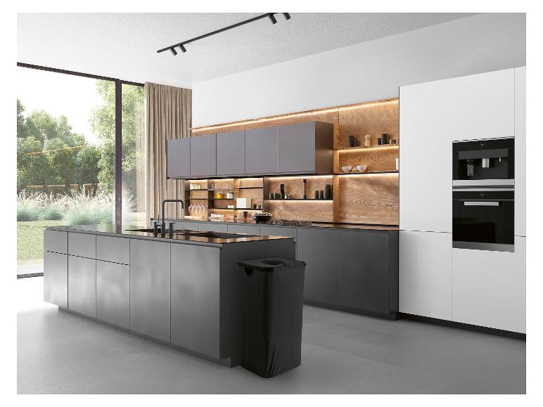 Moderne keuken met grijze kasten, houten accenten en een groot raam met uitzicht op de tuin.