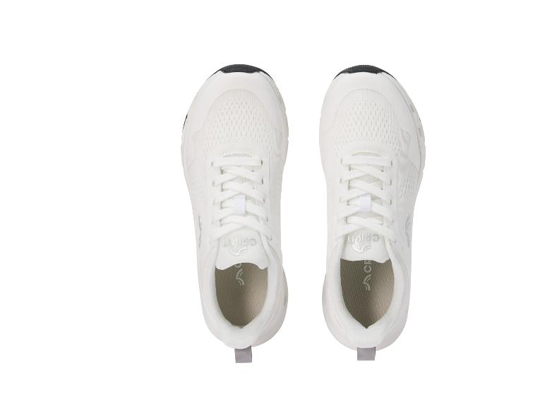 Een paar witte sportschoenen met zwarte en grijze details, van bovenaf gezien.